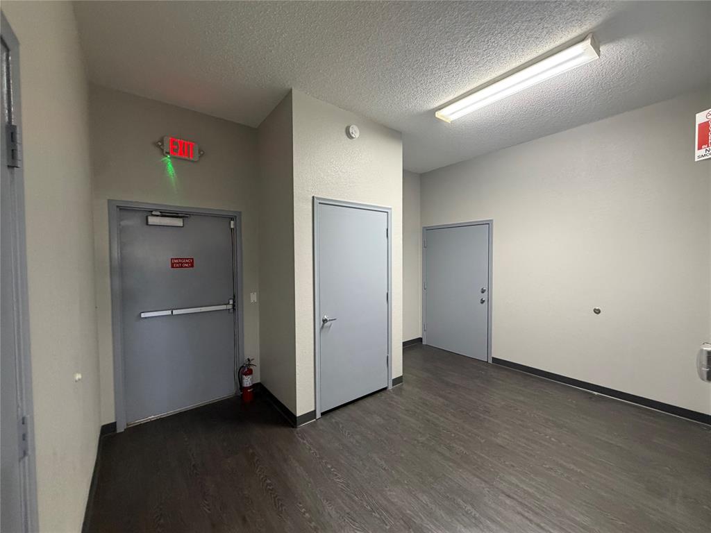 Rear corridor with a marked emergency exit and two private room doors