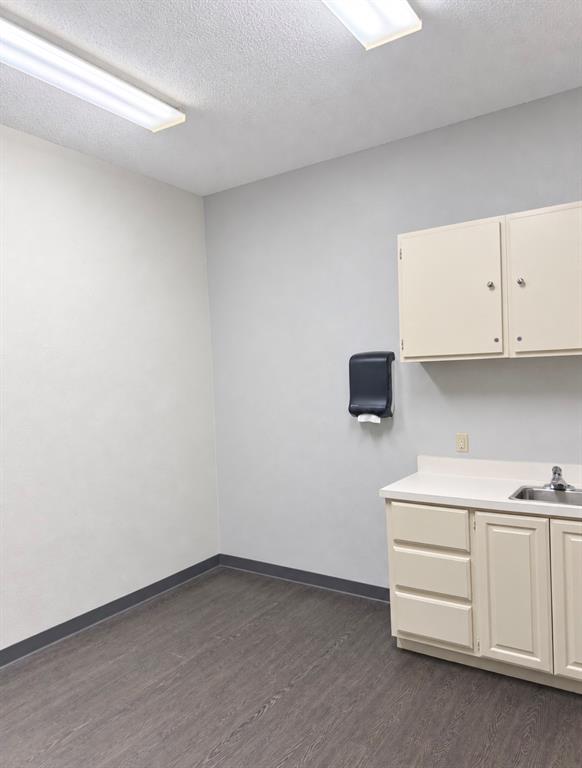 Private room with a stainless sink, upper and lower cabinets, and a wall-mounted towel dispenser