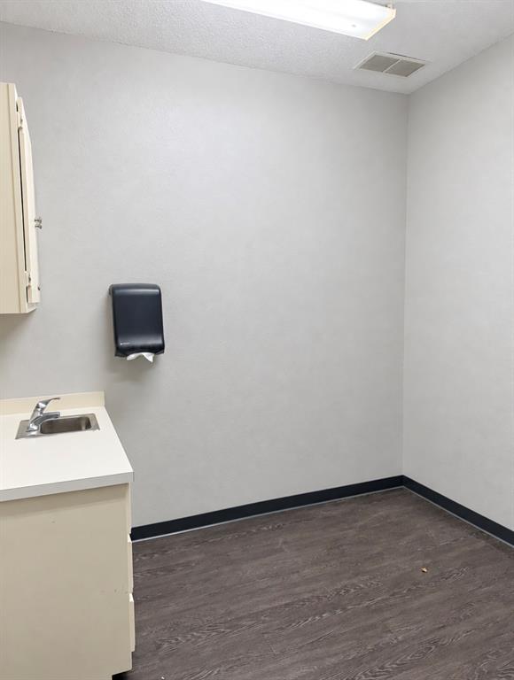 Third private room with a corner sink, cabinet, and towel dispenser