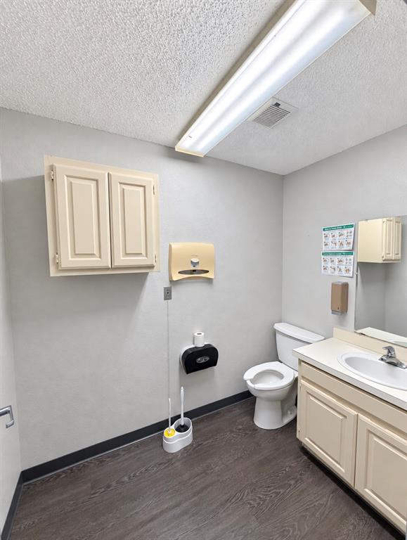 Private restroom with a vanity, sink, storage cabinet, and handwashing signage