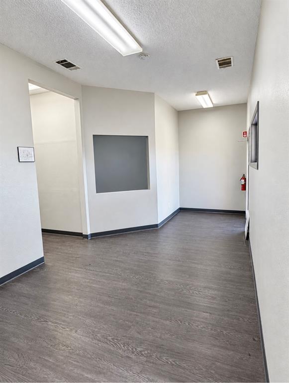 Waiting area with a reception check-in window and hallway leading to the clinical rooms